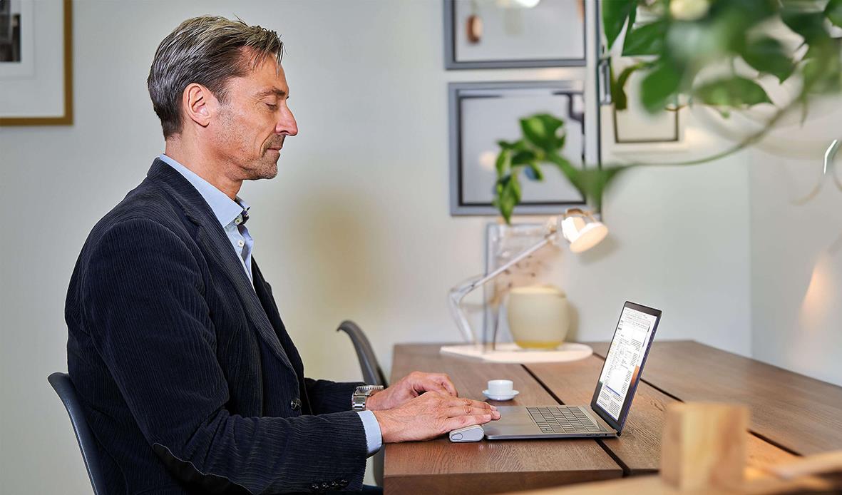 Man använder en trådlös ergonomisk RollerMouse Go vid skrivbordet i ett hem eller kontor