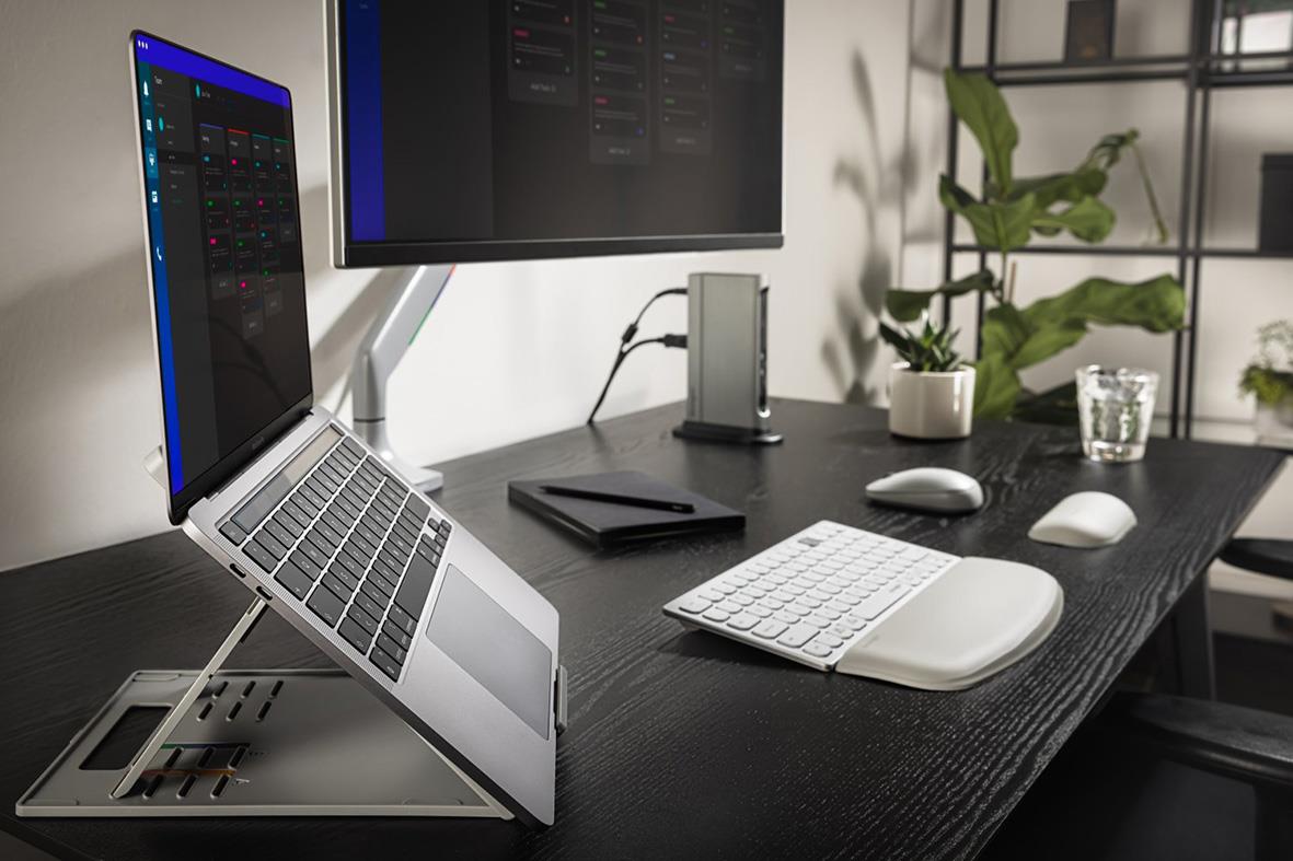 Justerbart laptopstöd Kensington EasyRiser Go på skrivbord med laptop, skärm, tangentbord och växter