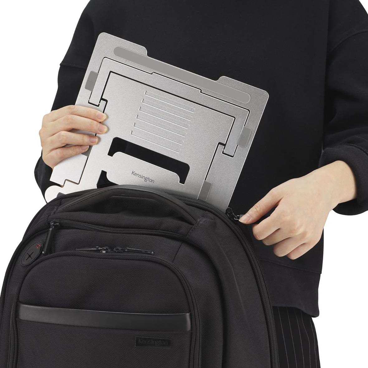 Person håller ett justerbart laptopstöd Kensington EasyRiser framför en svart ryggsäck
