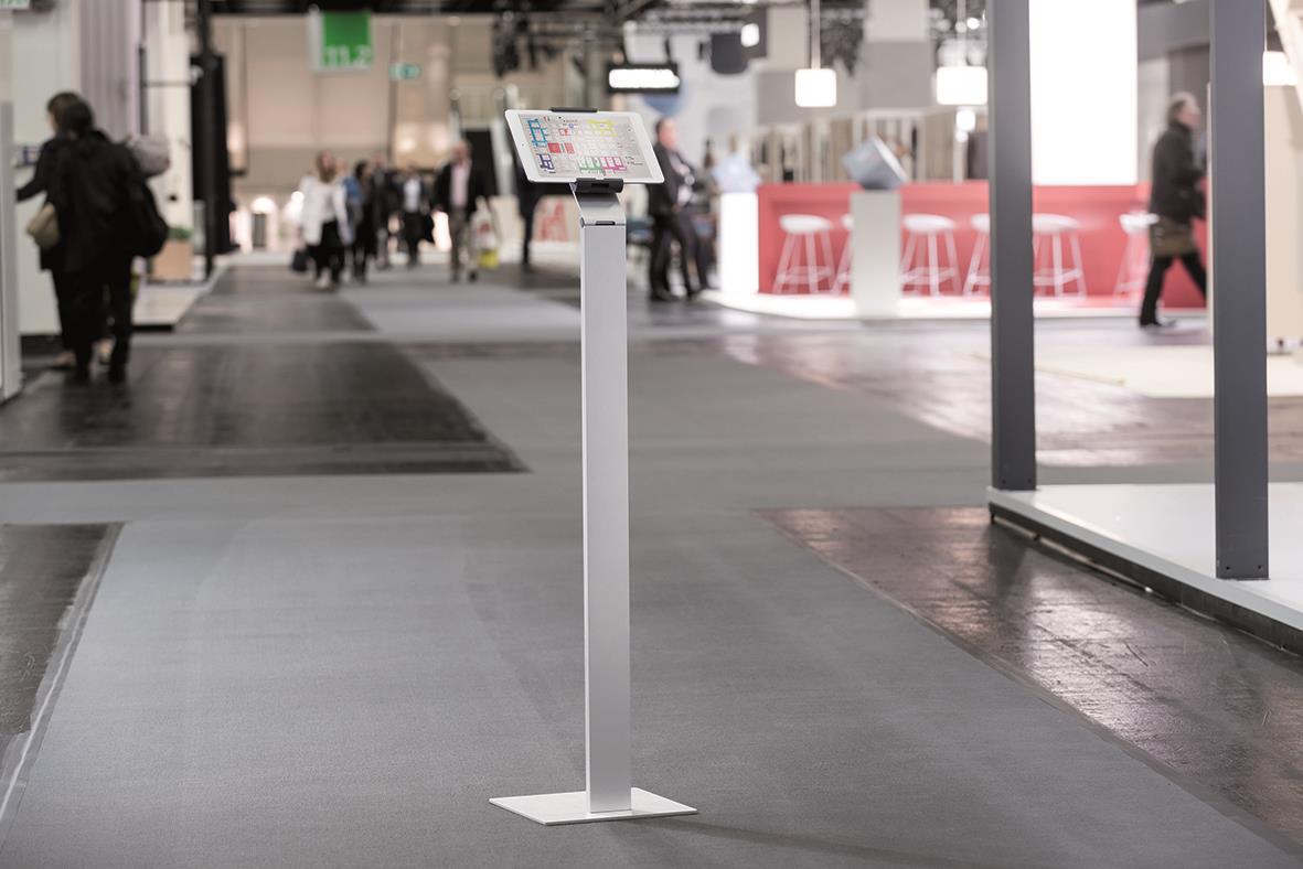 Golvställ för surfplatta på golvet i en offentlig plats med människor i bakgrunden