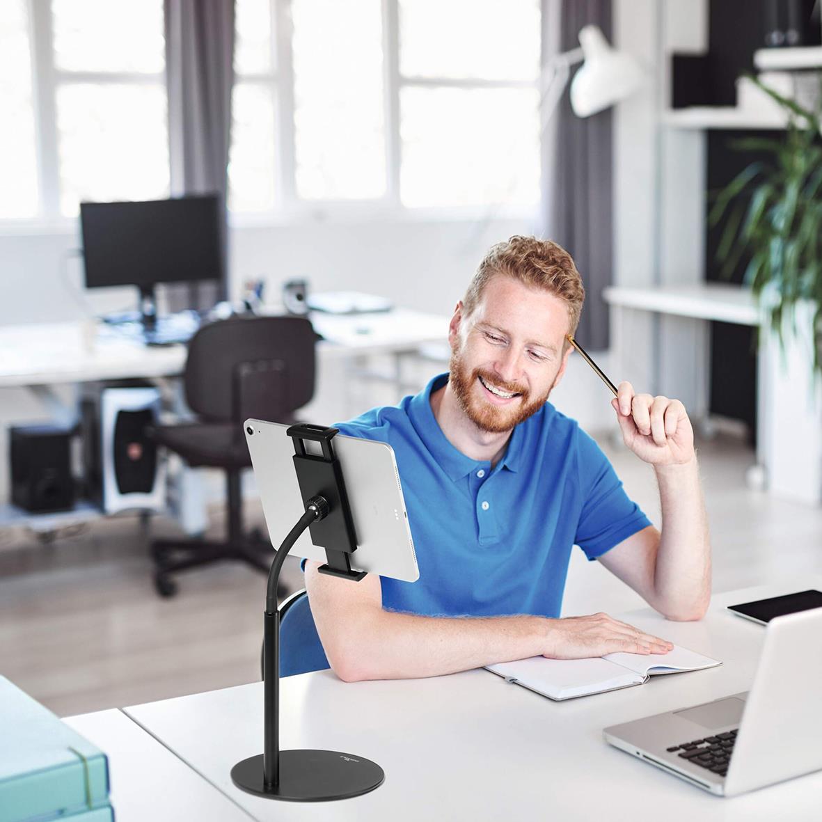 Glad man i kontorsmiljö använder surfplattehållare Twist Bord Svart