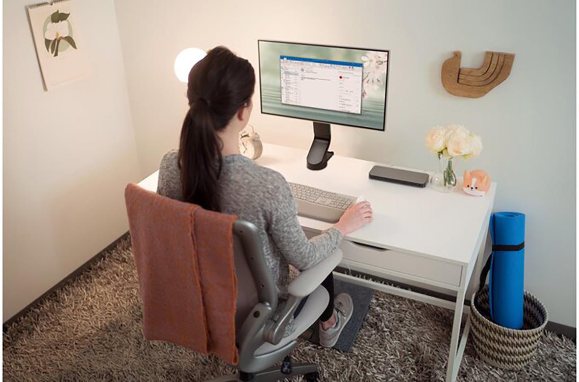 Person som arbetar vid skrivbord med monitorarm Kensington SmartFit Enkel i ett hemmakontor