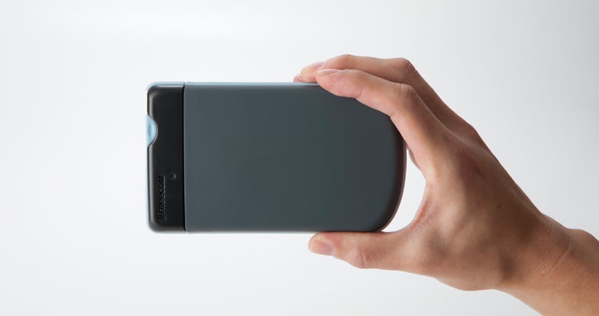 Hand som håller en svart Freecom Mobile ToughDrive 1TB hårddisk