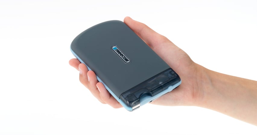 Hand som håller en grå Freecom Mobile ToughDrive 1TB hårddisk
