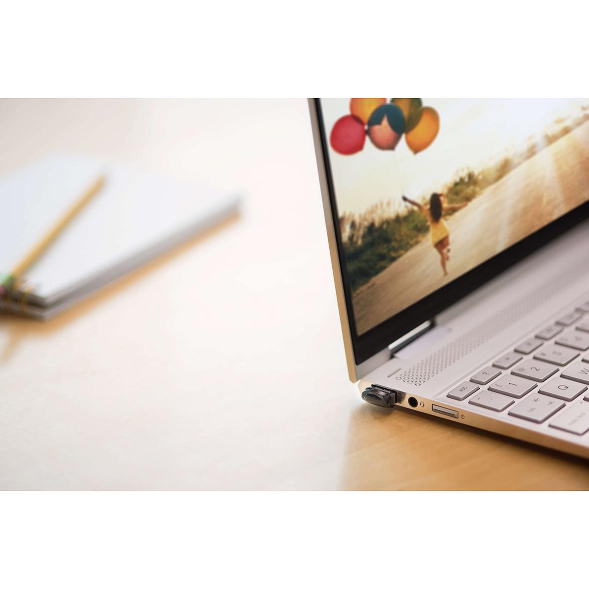 USB-minne Sandisk UltraFit 3.1 32GB placerad bredvid en laptop på ett skrivbord