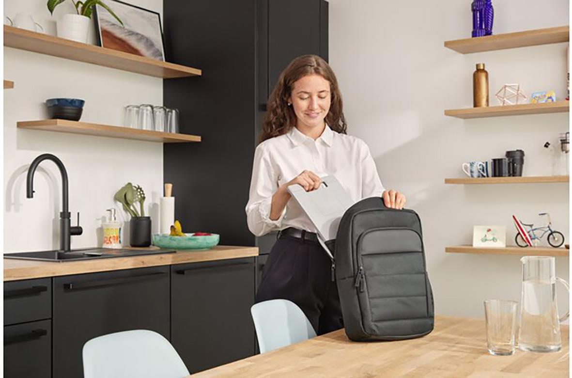 Kvinna packar en svart Kensington EQ 14 tum ryggsäck i ett modernt kök