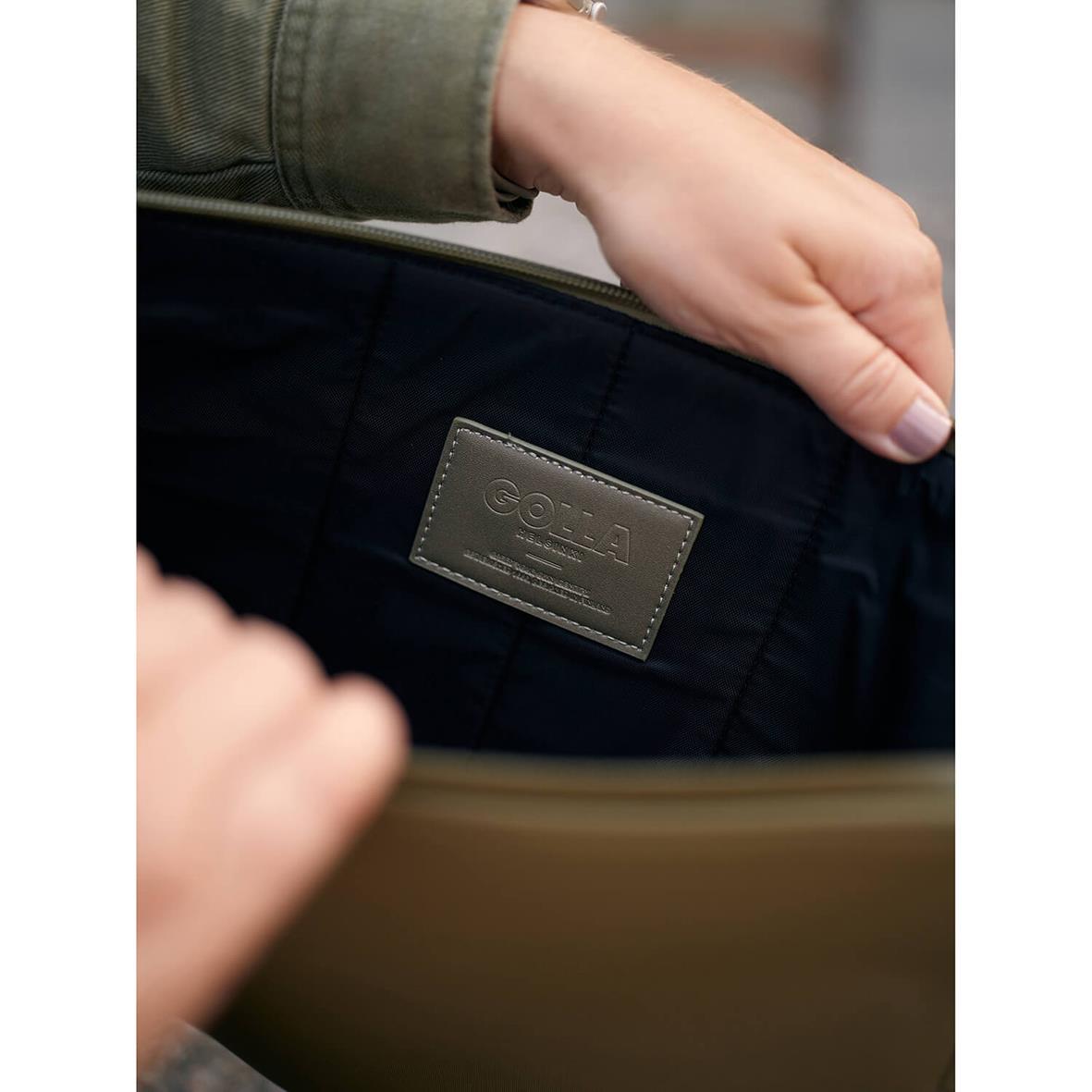 Grönt neopren datorfodral för 13 tum Golla Metro, visad i en persons hand