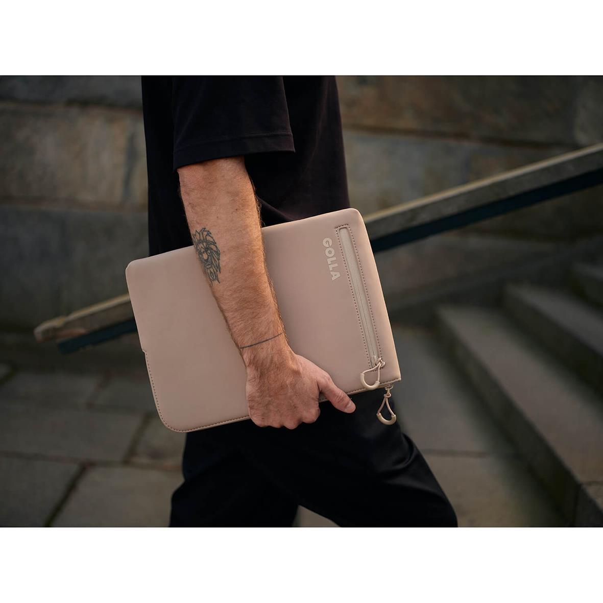 Person håller i ett beige neopren datorfodral Golla Metro för 13 tum, utomhus