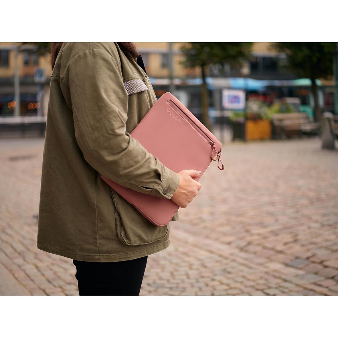 Person håller ett rosa neopren datorfodral Golla Metro Dirty Pink 13 tum utomhus på en gata
