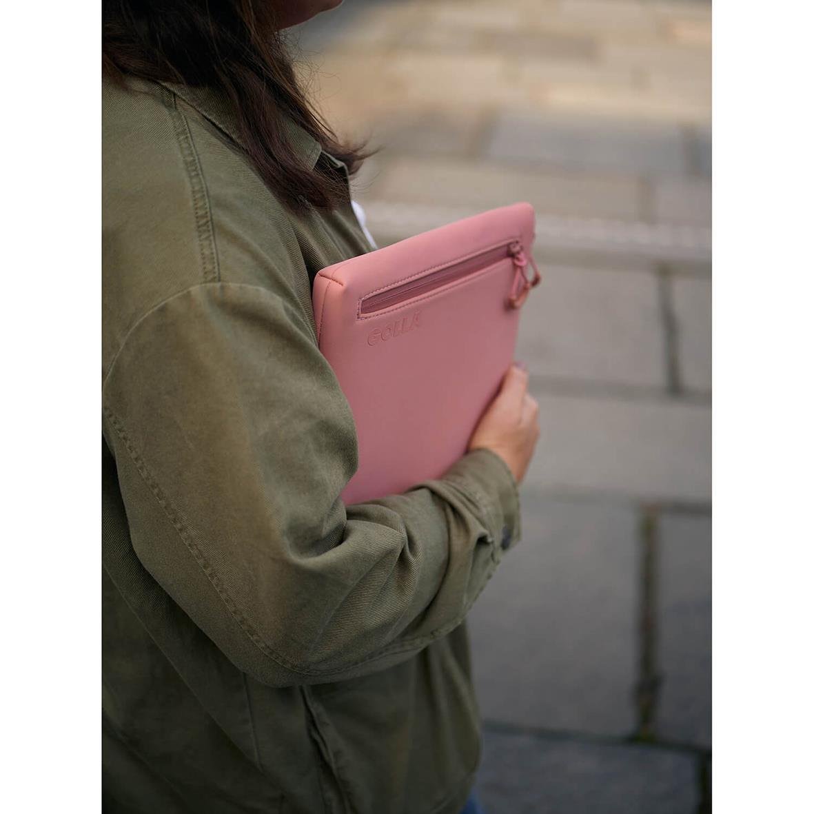 Person håller ett rosa neopren datorfodral för 13 tum med dragkedja