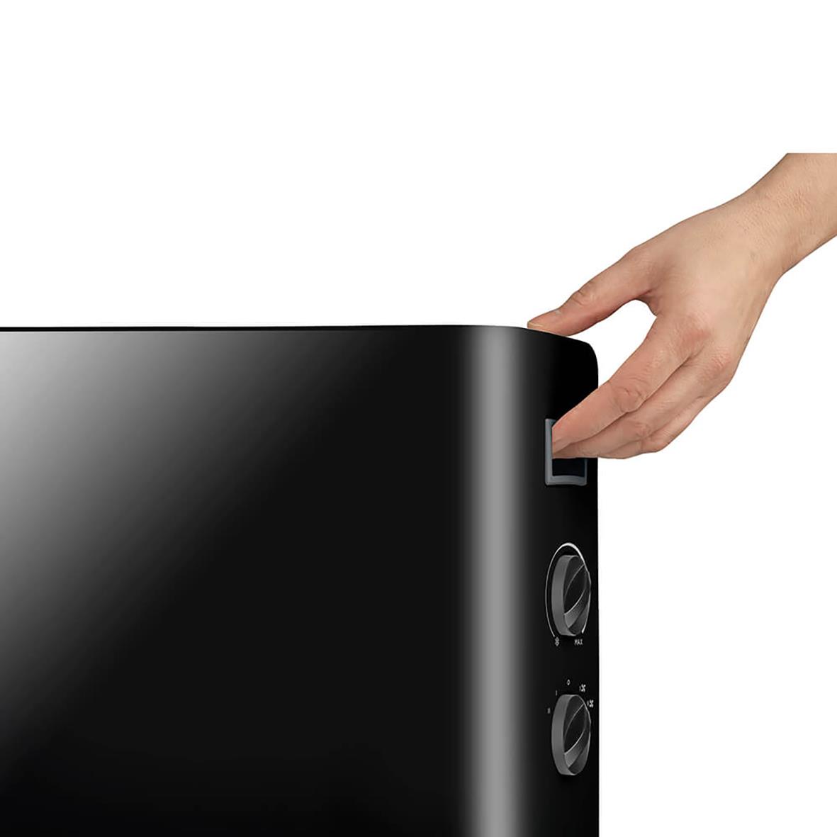 Hand som justerar svart konvektorelement Black+Decker 2000W