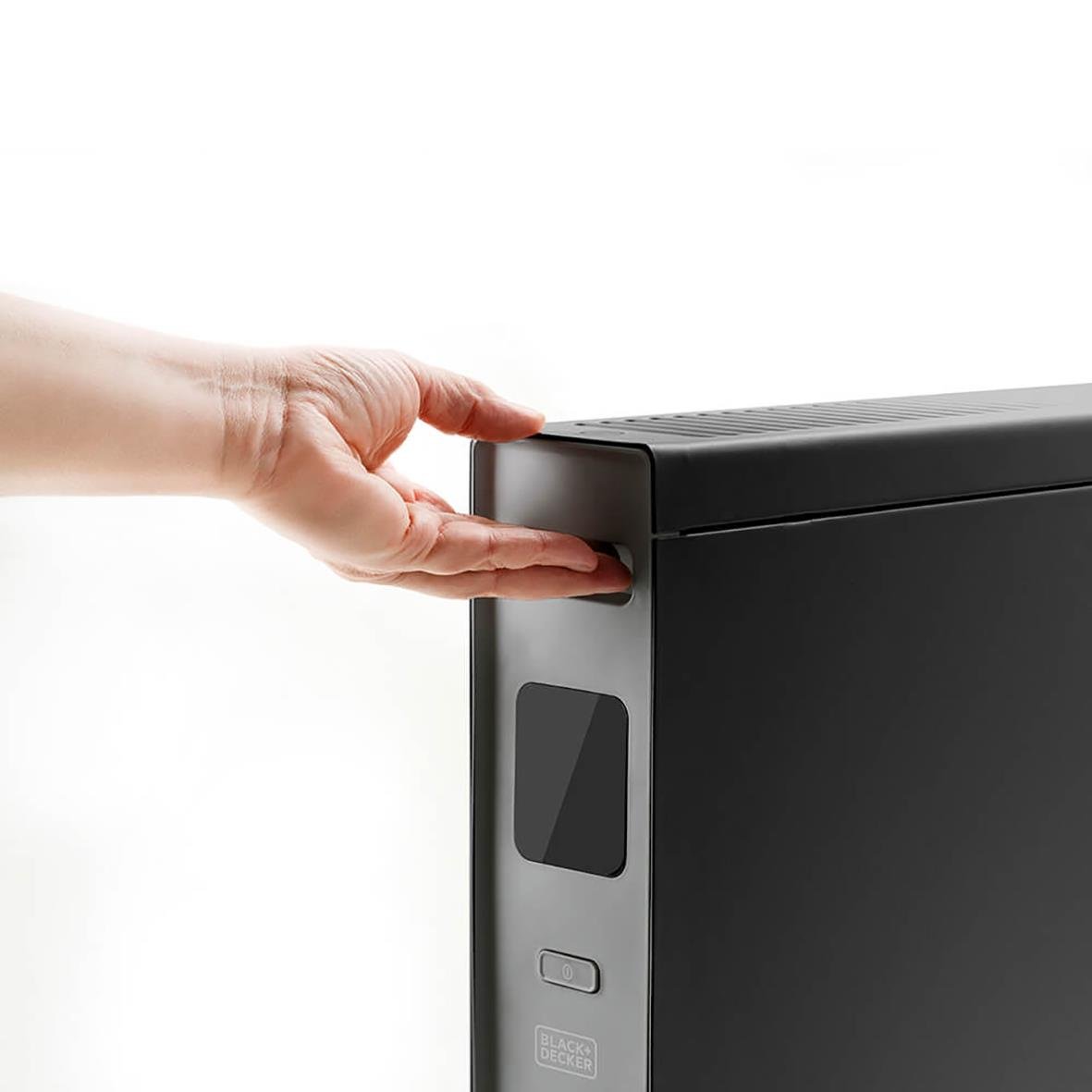 Hand som trycker på konvektorelement Black+Decker Digital 2000W svart