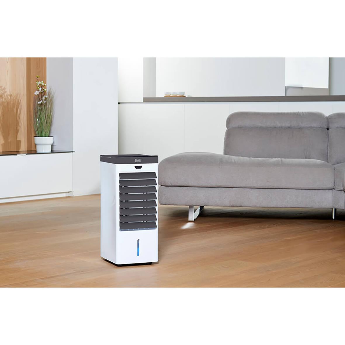 Vit luftkylare Black+Decker Air Cooler BXAC50x i vardagsrum med soffa och växter