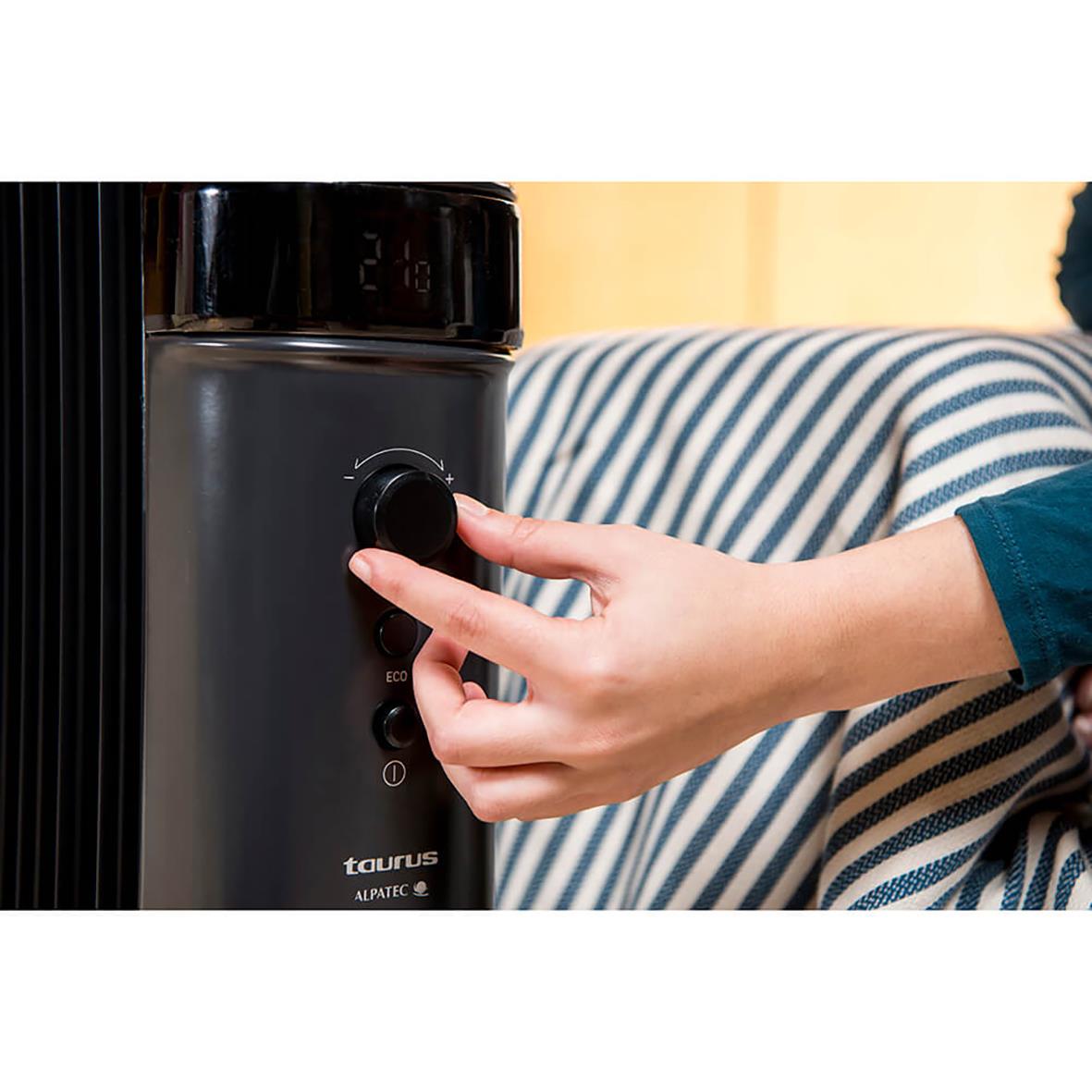 Hand som justerar inställningar på svart Element Taurus oljefyllt Agadir 2000W värmeelement