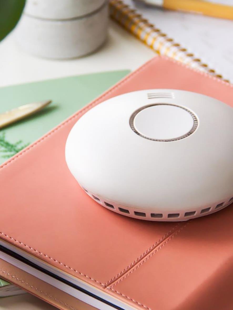 Trådlös brandvarnare Housegard SA422WS-S2 placerad på ett rosa anteckningsblock