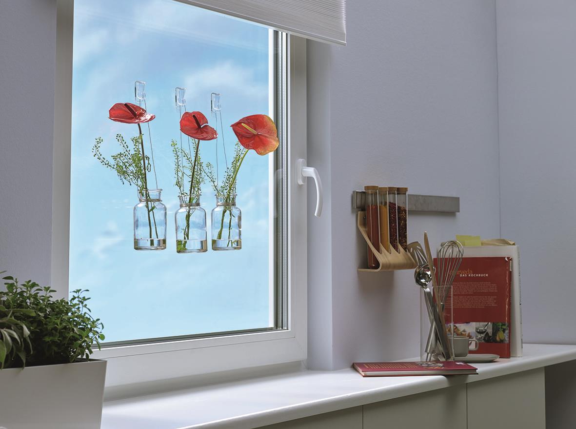 Transparent självhäftande krok med Tesa Powerstrips håller tre röda blomster i fönstret