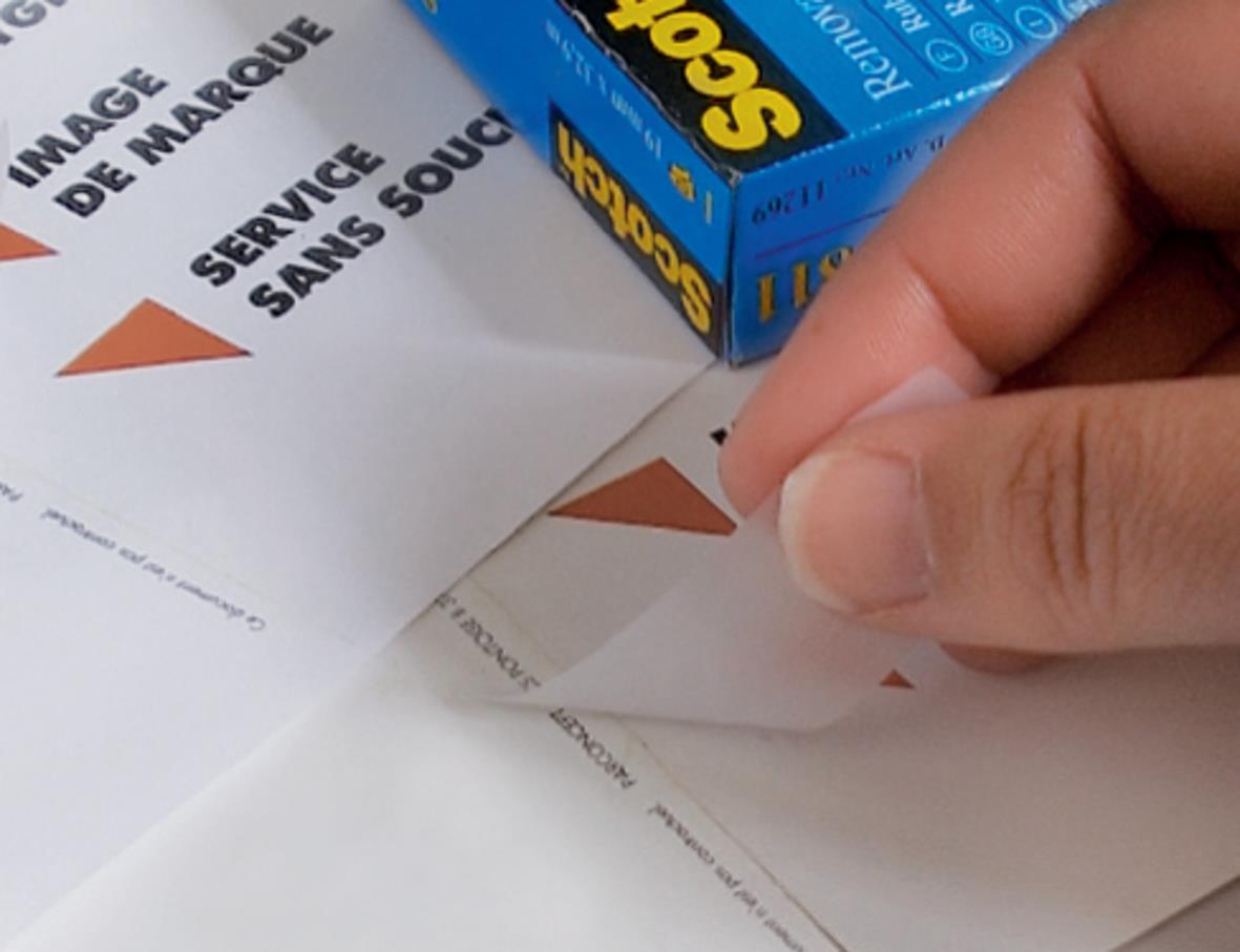 Person som applicerar Scotch Magic 811 dokumenttejp på ett papper