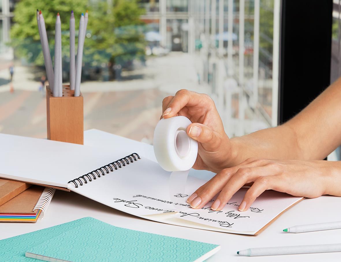 Person använder dokumenttejp Scotch Magic 900 på papper i ett kontorsmiljö