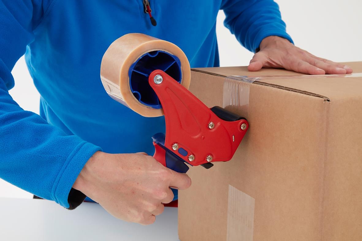 Person använder packtejp Tesa 4124 Premium PVC för att säkra en kartong
