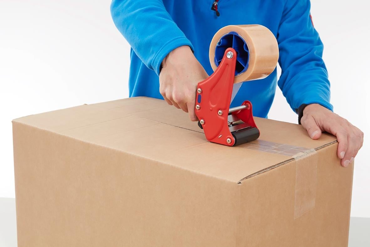 Person använder packtejp Tesa 4124 Premium PVC transparent på en kartong