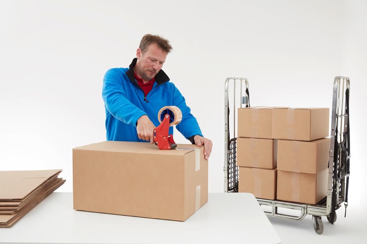 Man använder packtejp Tesa 4124 Premium PVC transparent för att försegla kartonger