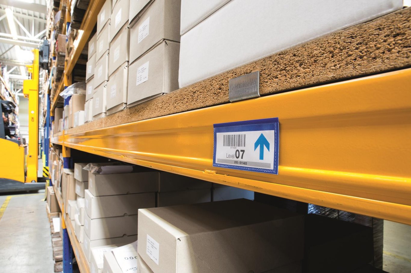 Blå magnetisk etikettbärare på lagerhylla med etikett