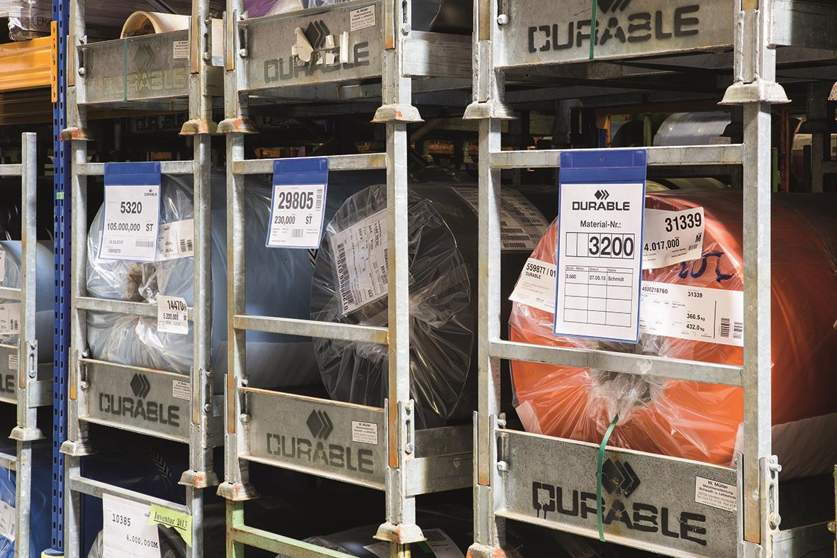 Blå plastfickor med neodymmagnet i lagerhylla, märkta med produktnummer och etiketter