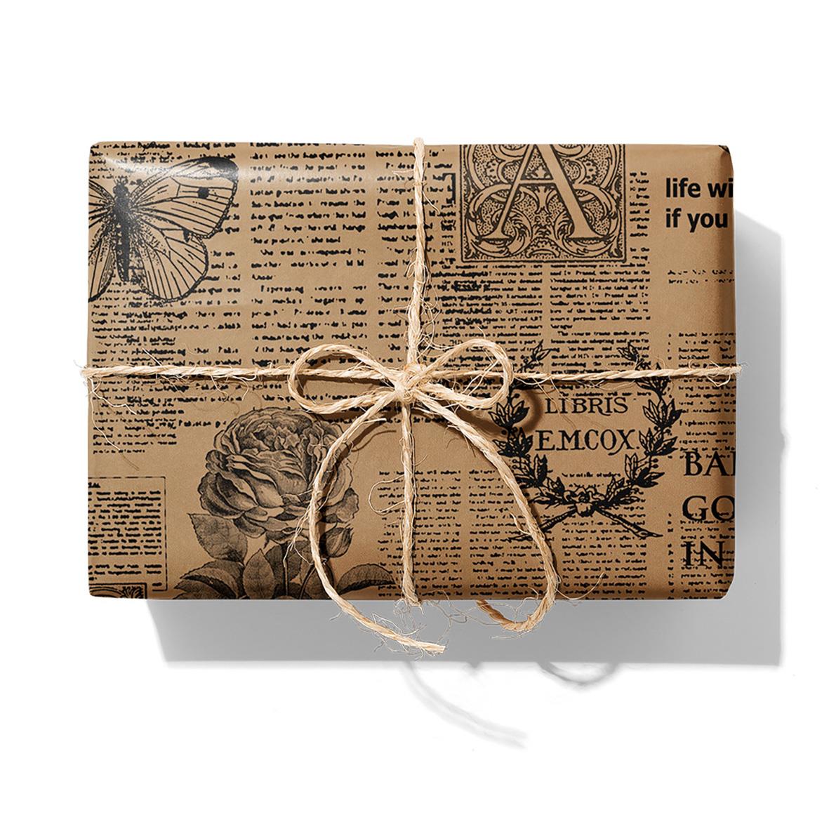 Presentpapper i brunt med tidnings- och fjärilsmotiv, knutet med snöre