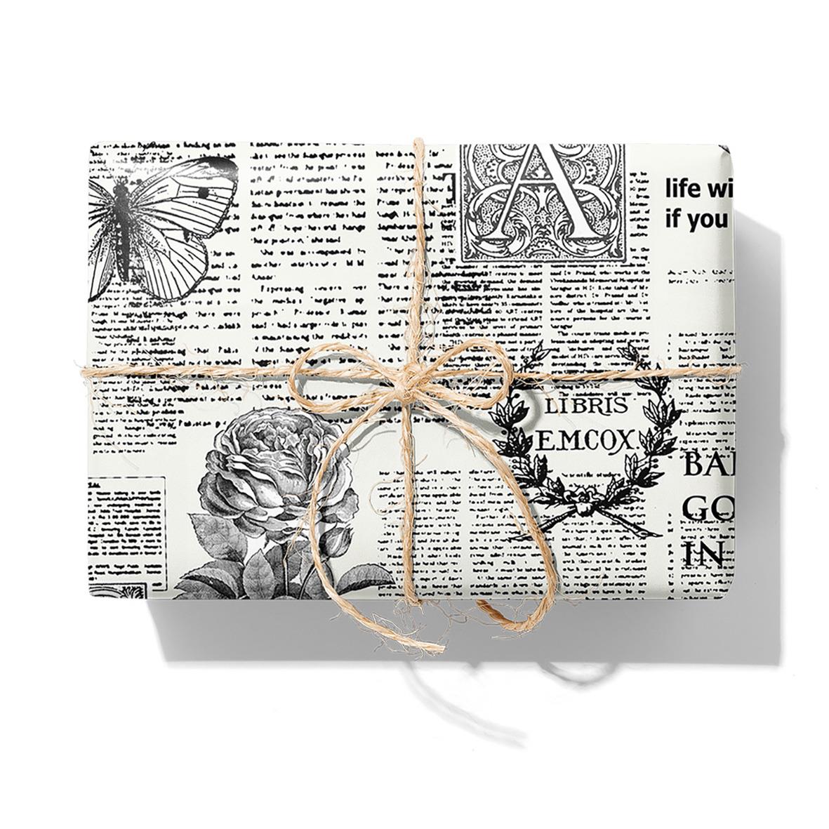 Presentpapper med nyhets- och bokmotiv i vitt och svart, 57cm x 154m, 7kg