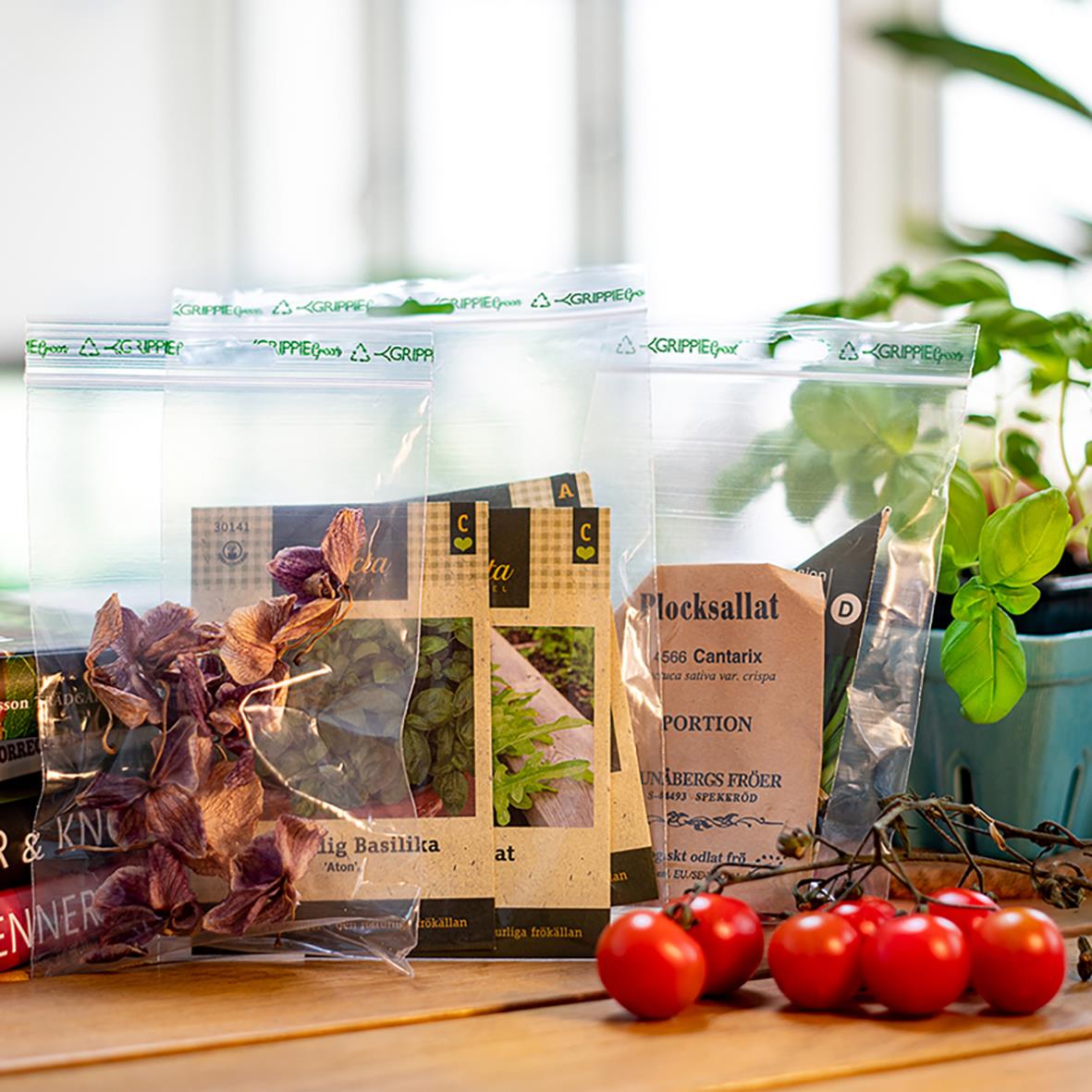 Gröna blixtlåspåsar utan skrivfält med växter och tomater på en träbänk