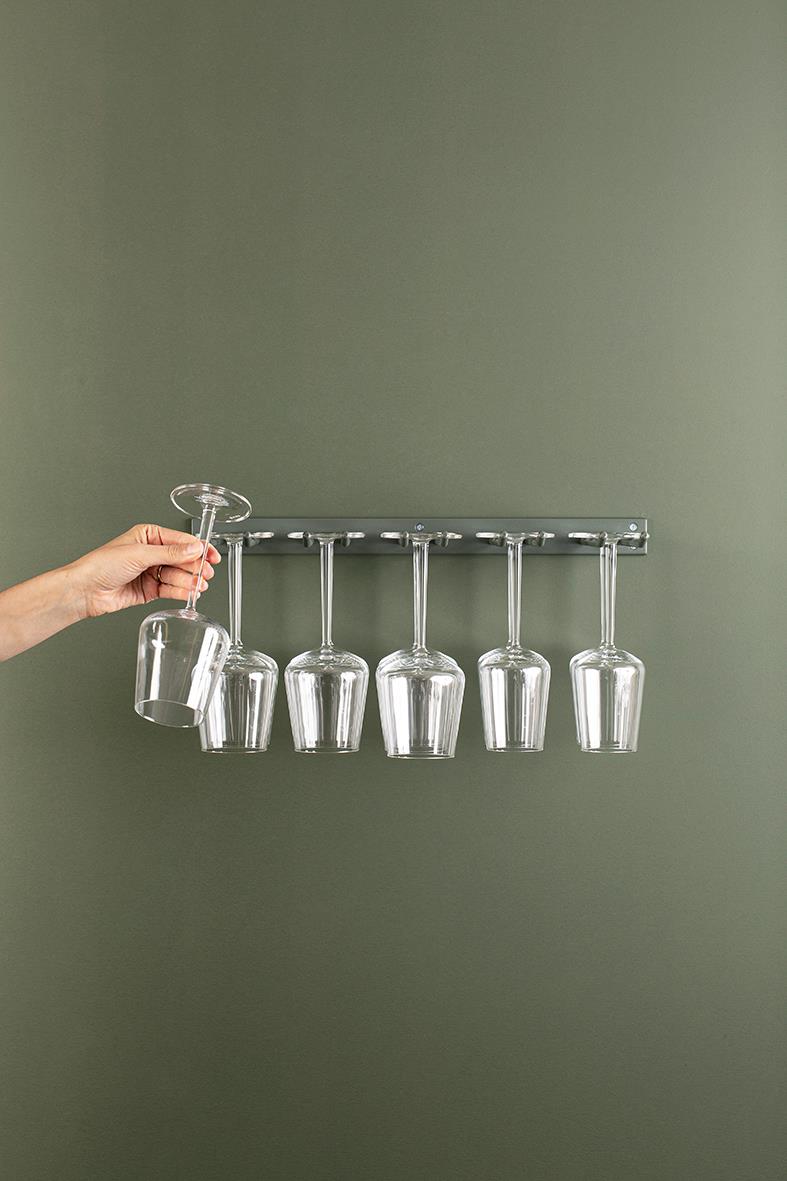 Kromglashängare för ca 15 vinglas, monterad på vägg, med en hand som placerar ett glas