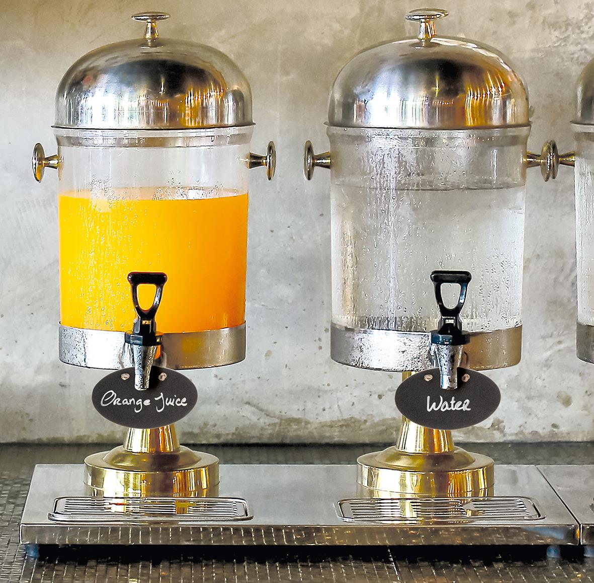 Två dryckesautomater, en med orange juice och en med vatten, med svarta etiketter och lädersnöre