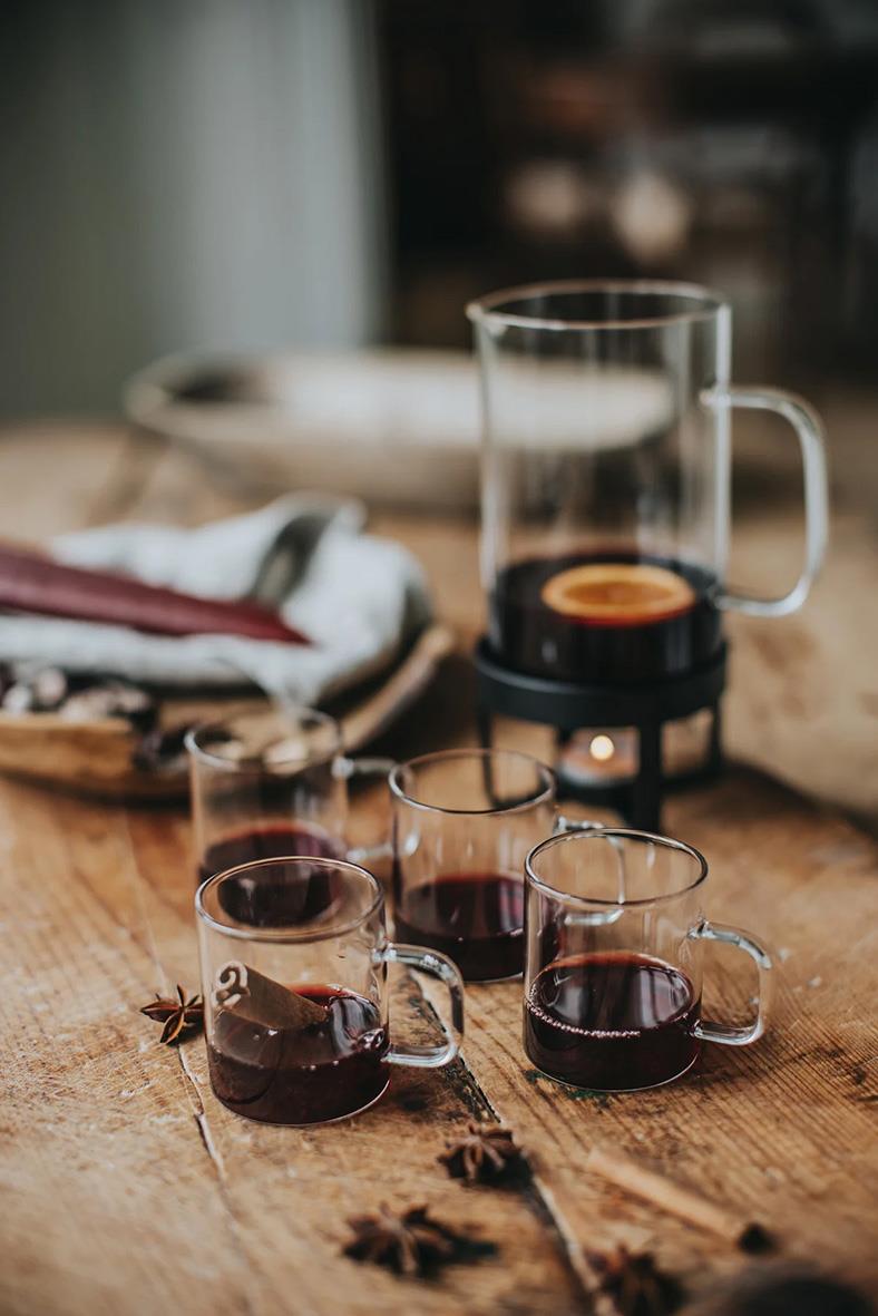 Glasmugg Dorre 1,8dl med röd dryck, tre små glas och en kaffebryggare på träbord