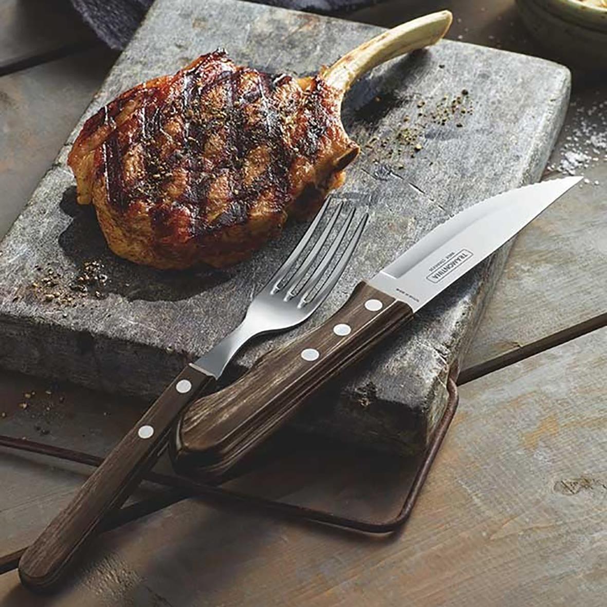 Grillkniv Tramontina Jumbo Brun 252mm bredvid en grillad köttbit på en stenplatta