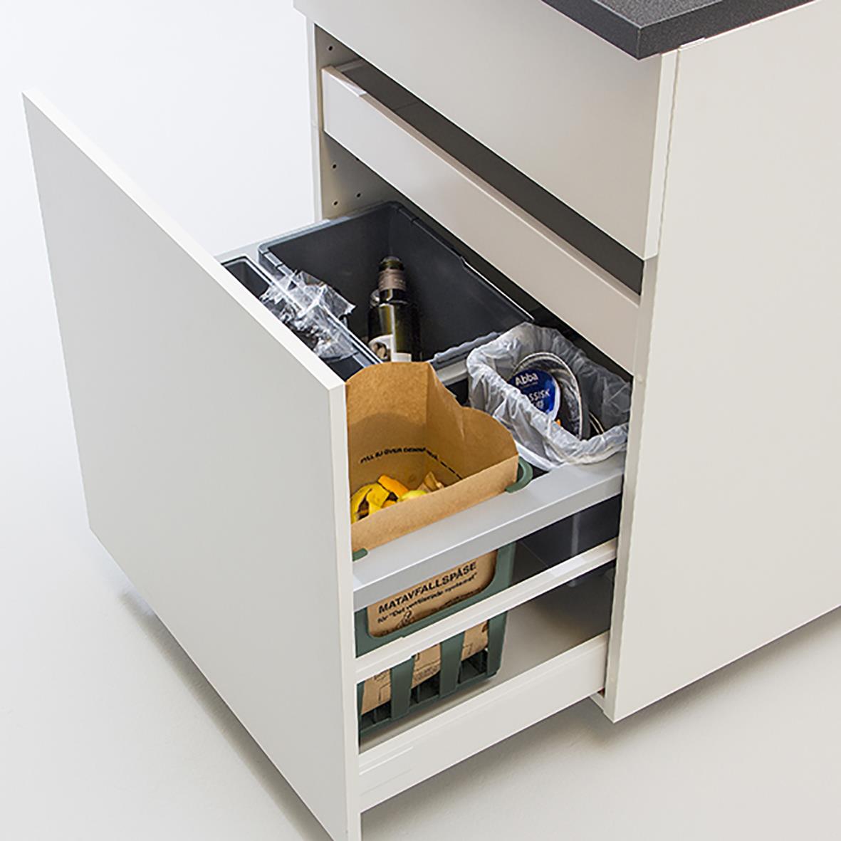 Matavfallskorg med matavfall i ett köksskåp