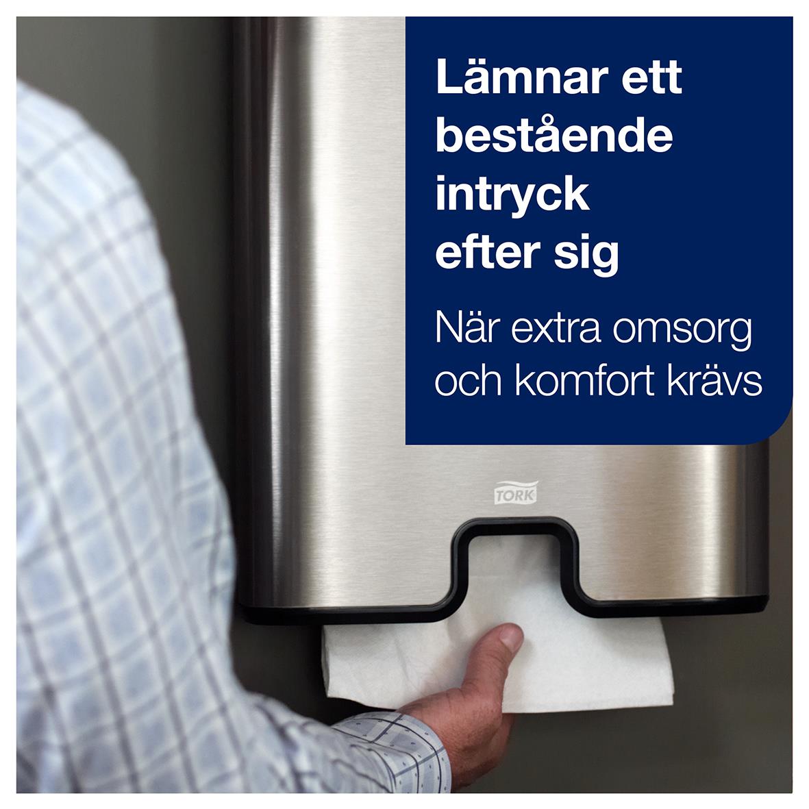 Pappershandduk Tork H2 Prem Ex Soft 2-lg 210x340mm som används för att torka händer, med en person som tar en handduk