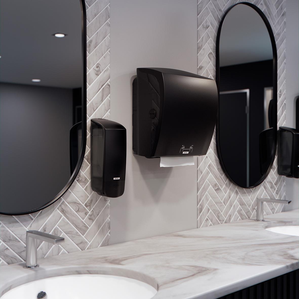 Två speglar, handduksdispenser och pappershanddukssystem på badrumsvägg med marmoryta