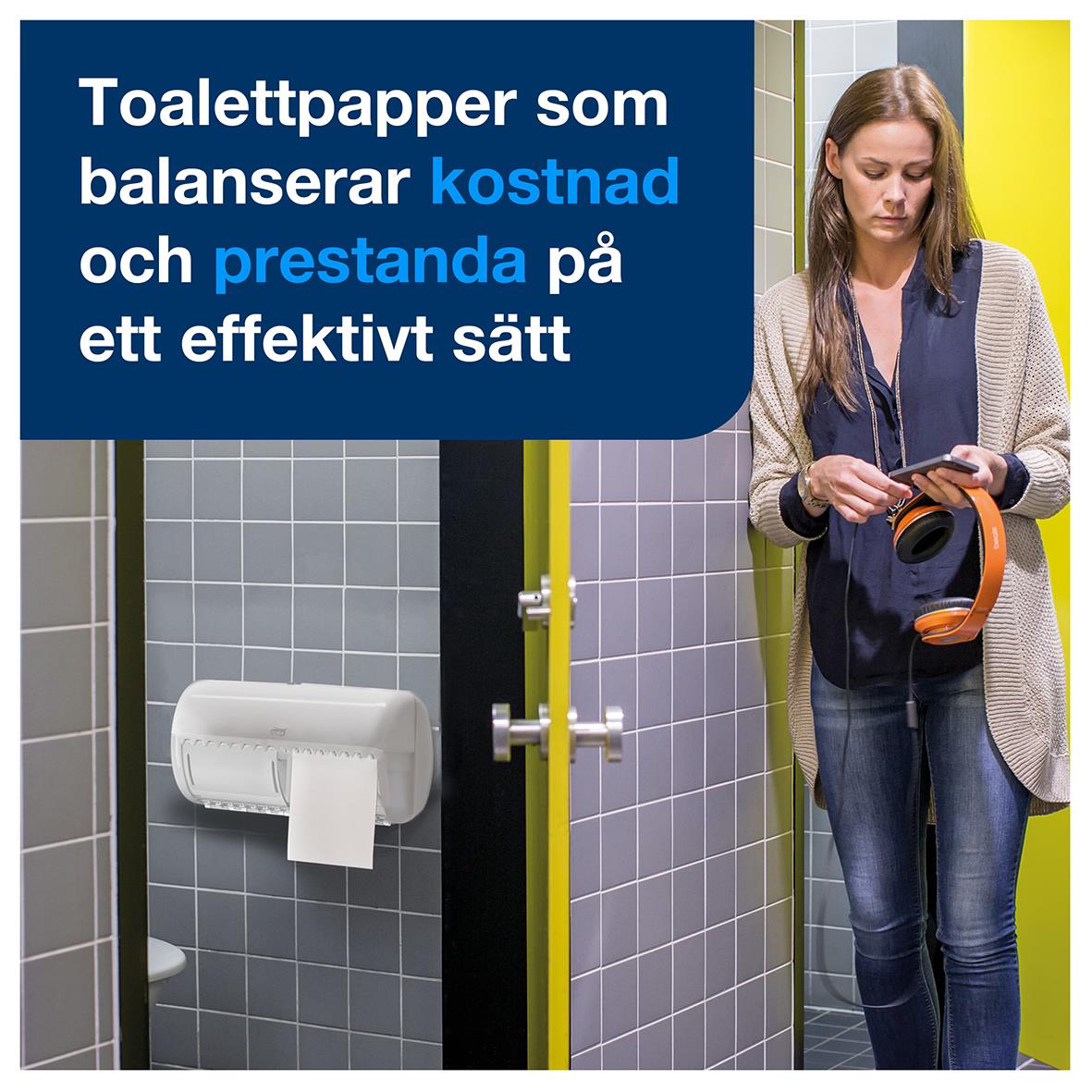 Kvinna i toalett med Tork T4 Universal 1-lags toalettpapper på vägg