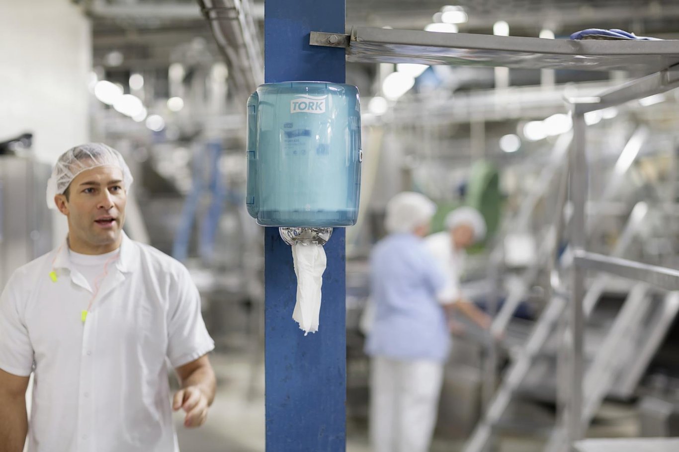 Torkrulle Tork M2 Basic 1-lag Gul 215mmx300m i industriell miljö med personal