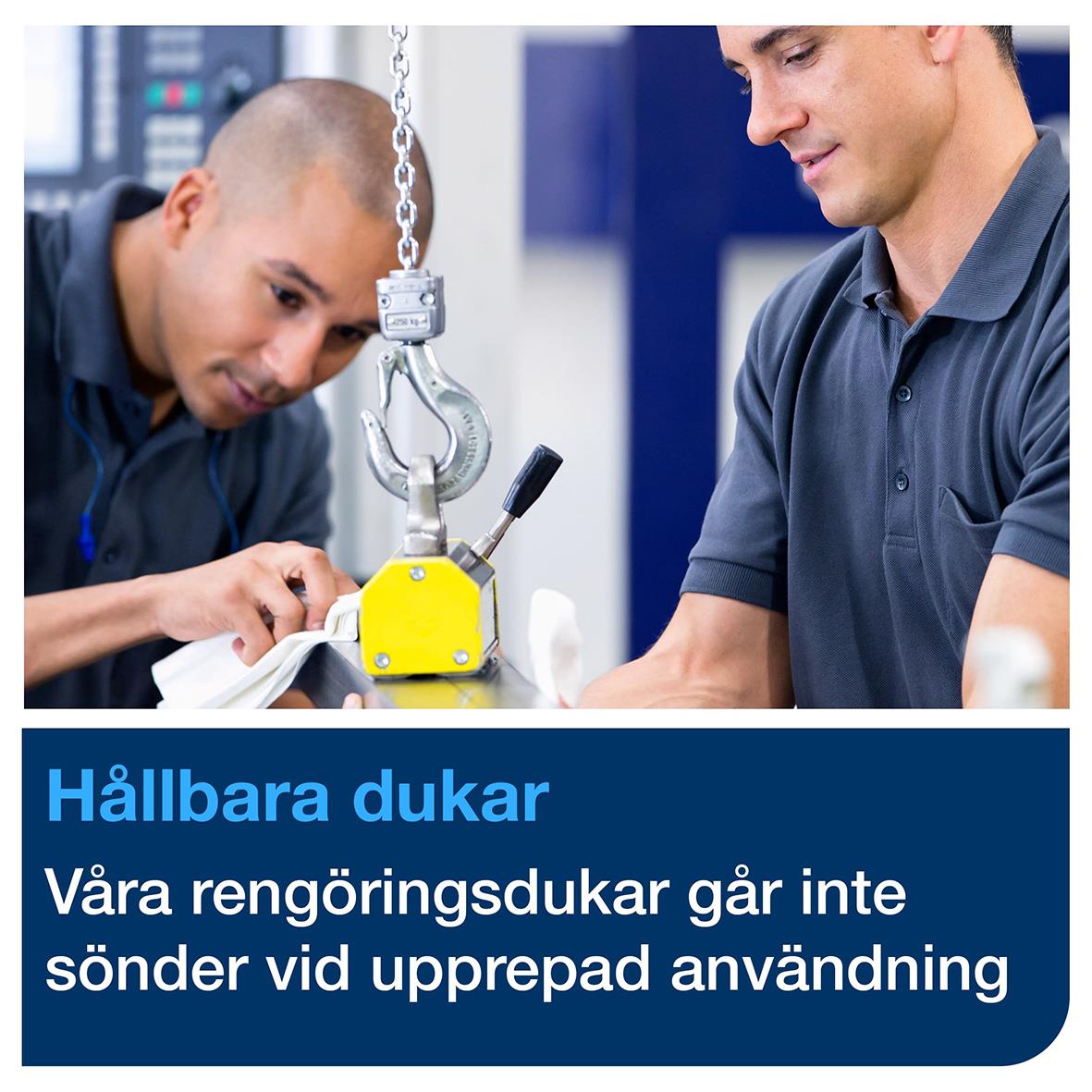 Två personer arbetar med rengöringsutrustning i en industriell miljö, en av dem använder en lyftanordning för att hantera utrustning