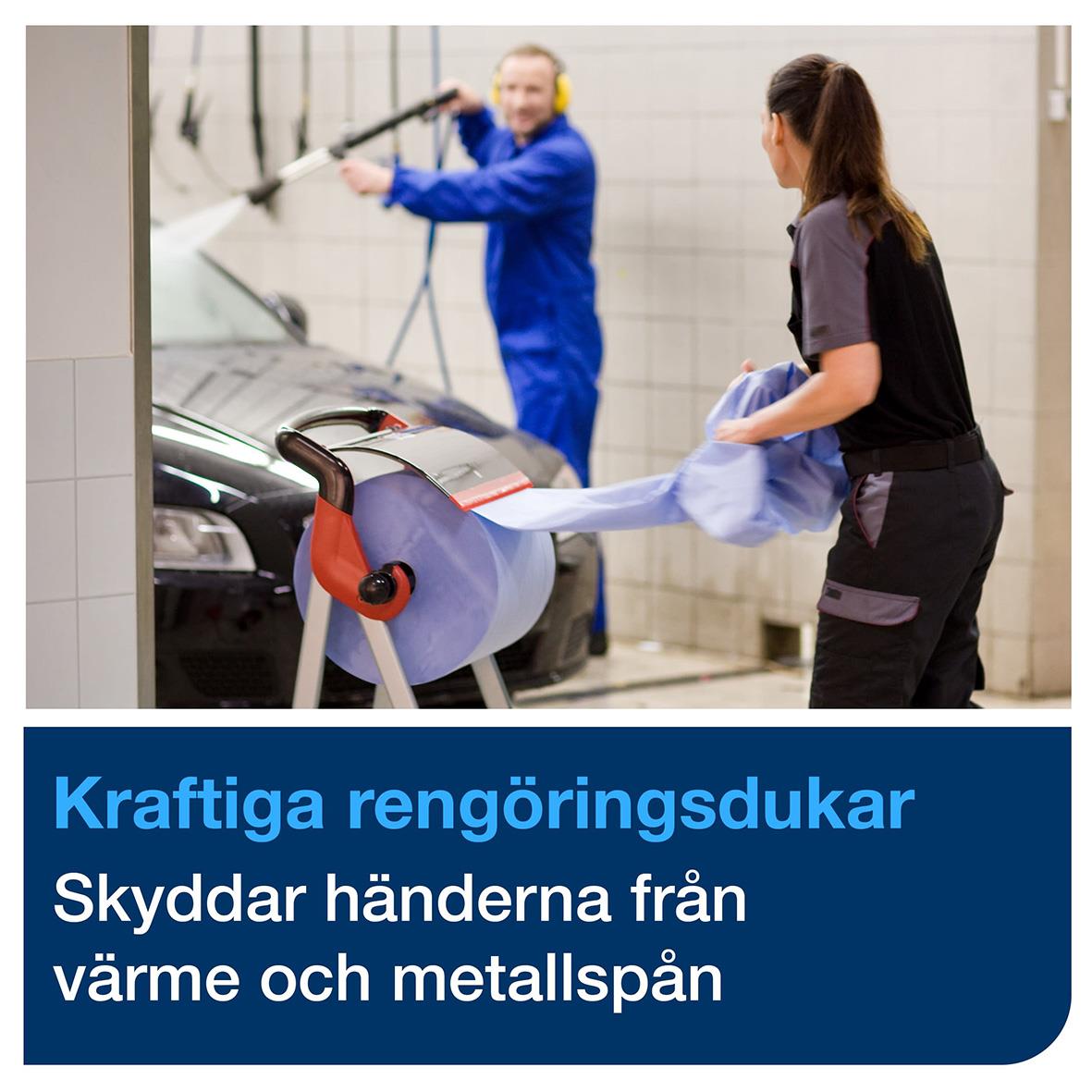 Två personer rengör en bil med kraftiga rengöringsdukar i en tvättstation, en person i blå arbetskläder och en annan i svart.