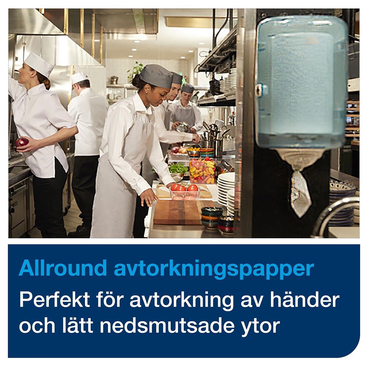 Köksmiljö med personal som hanterar mat, och en väggmonterad handdesinfektionsstation