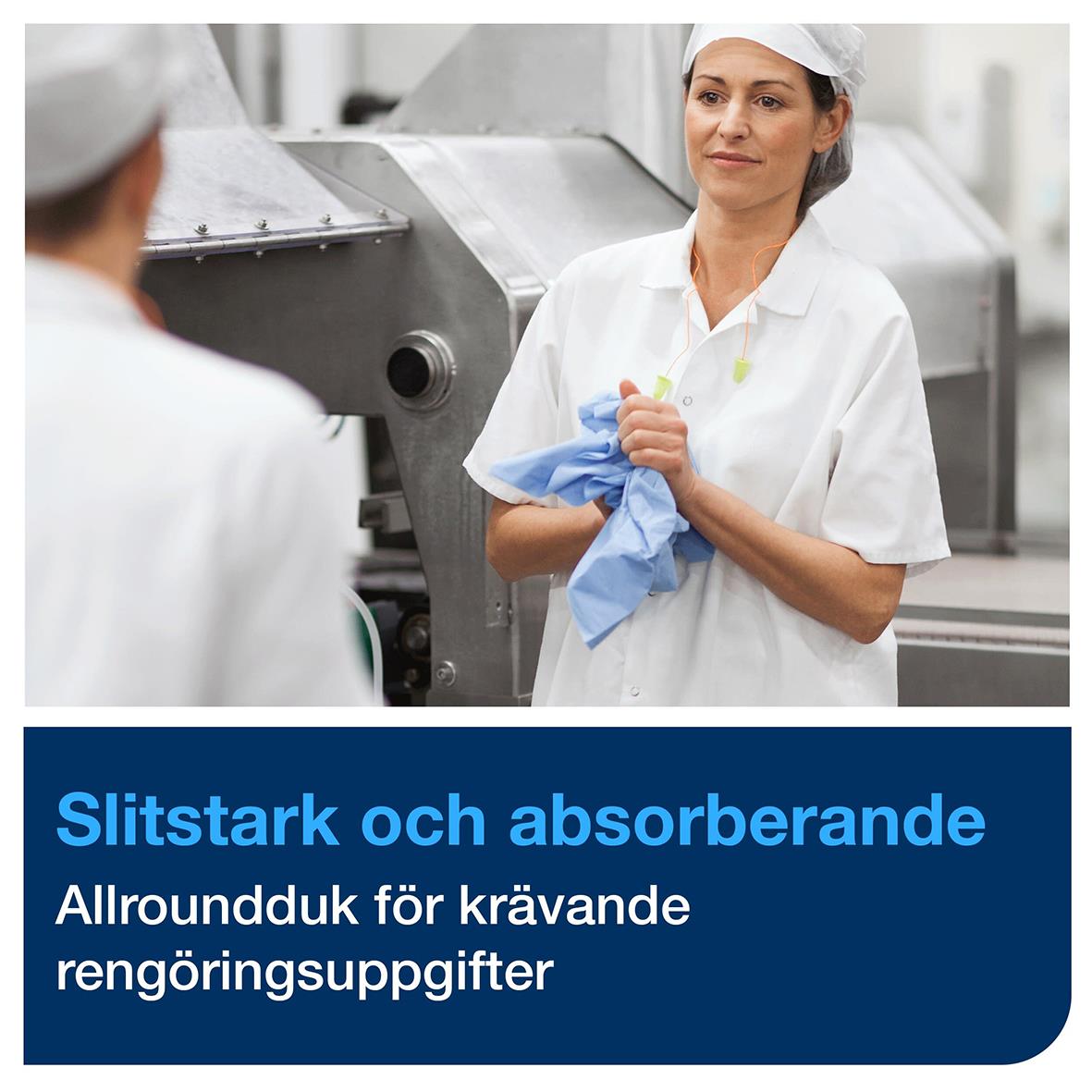 Kvinna i arbetskläder håller en blå rengöringsduk i en industriell miljö