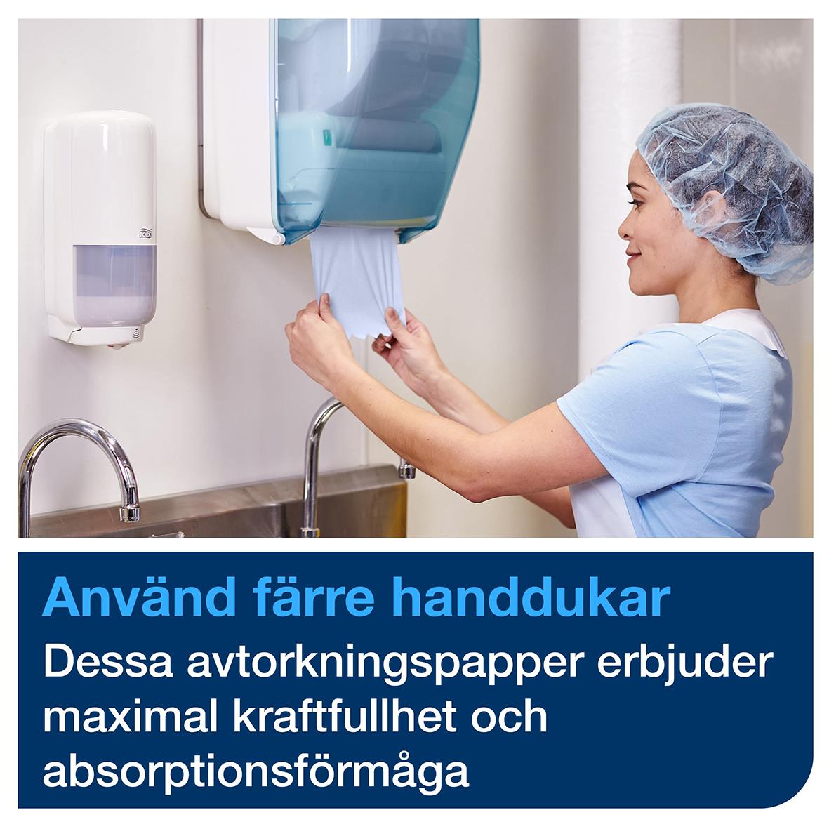 Person i sjukhusuniform använder handskar och hanterar torkpapper från en dispenser i ett kliniskt kök eller badrum