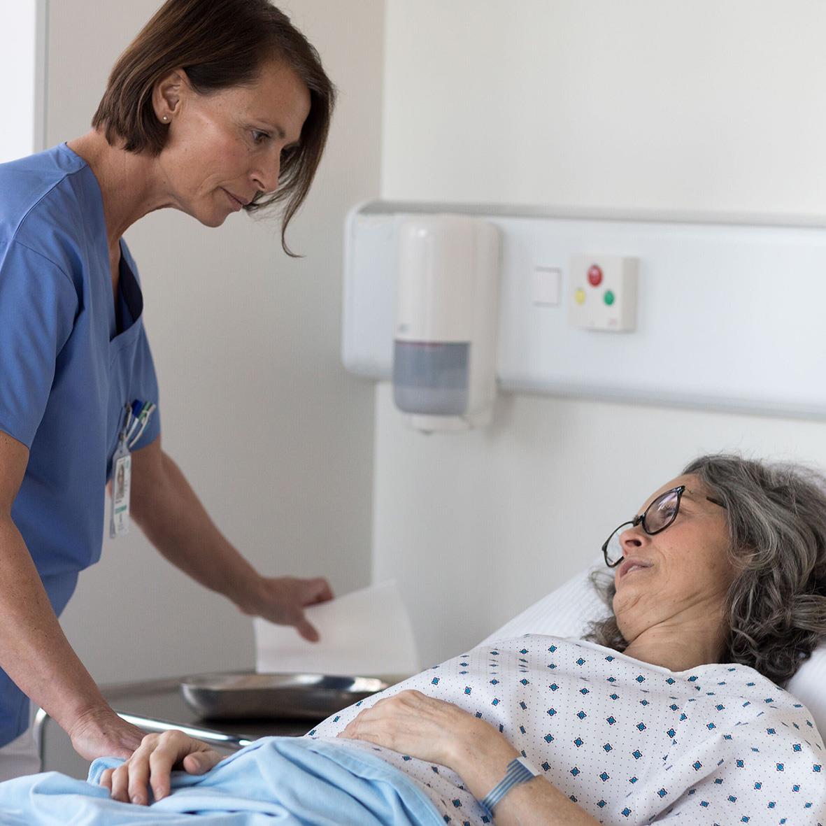 Sjuksköterska ger en patient en tvättlapp på sjukhus