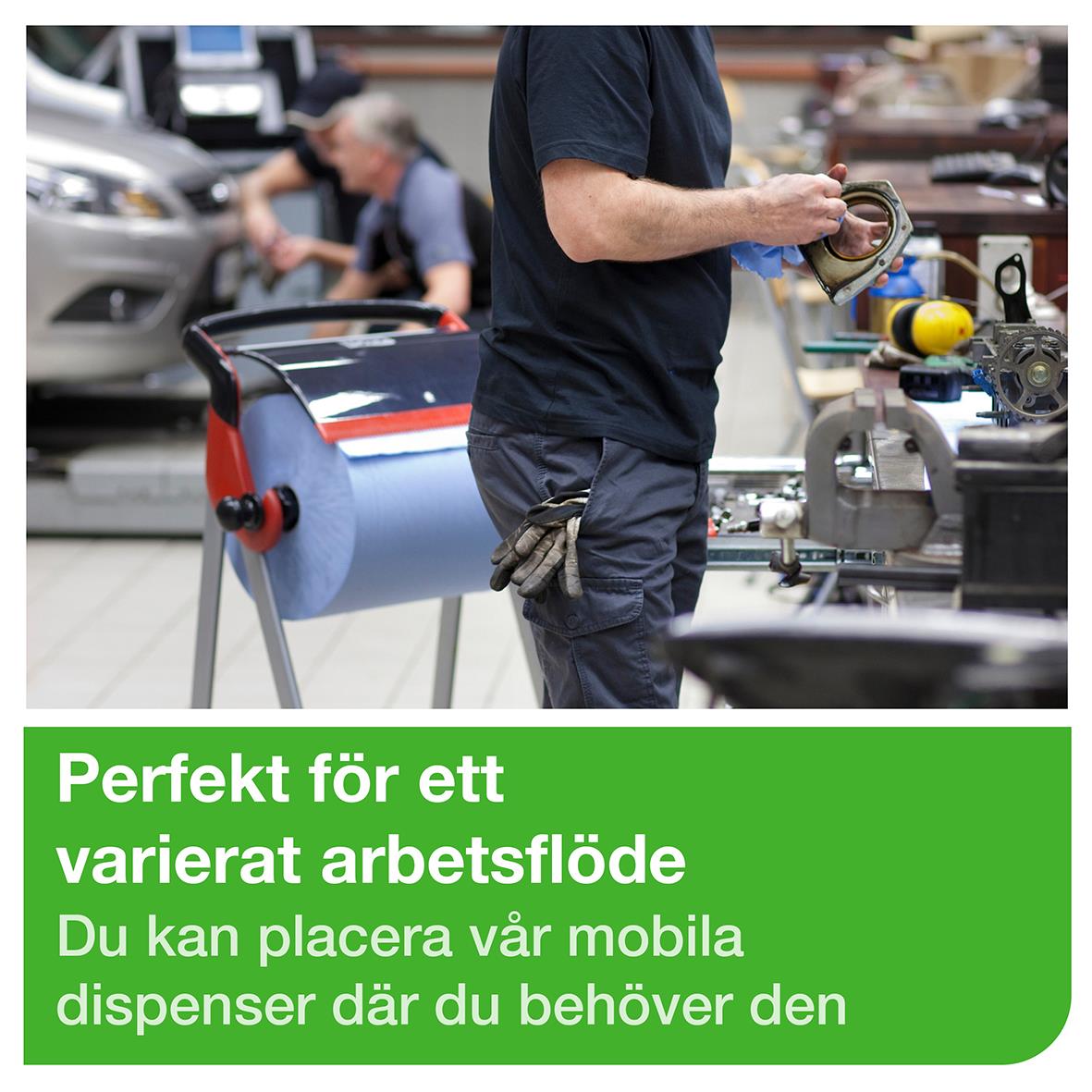 " Tork W1 golv med hjul i röd och svart, används för att hänga och förvara torkdukar i arbetsmiljö."