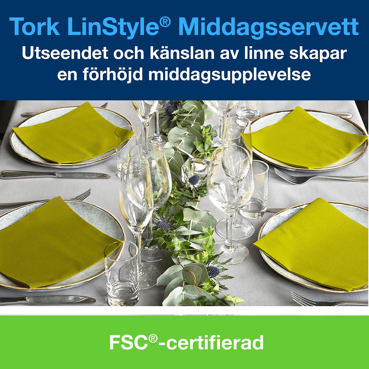 Servett Tork LinStyle Pistage 39x39cm på dukat bord med gröna servetter, glas och bestick
