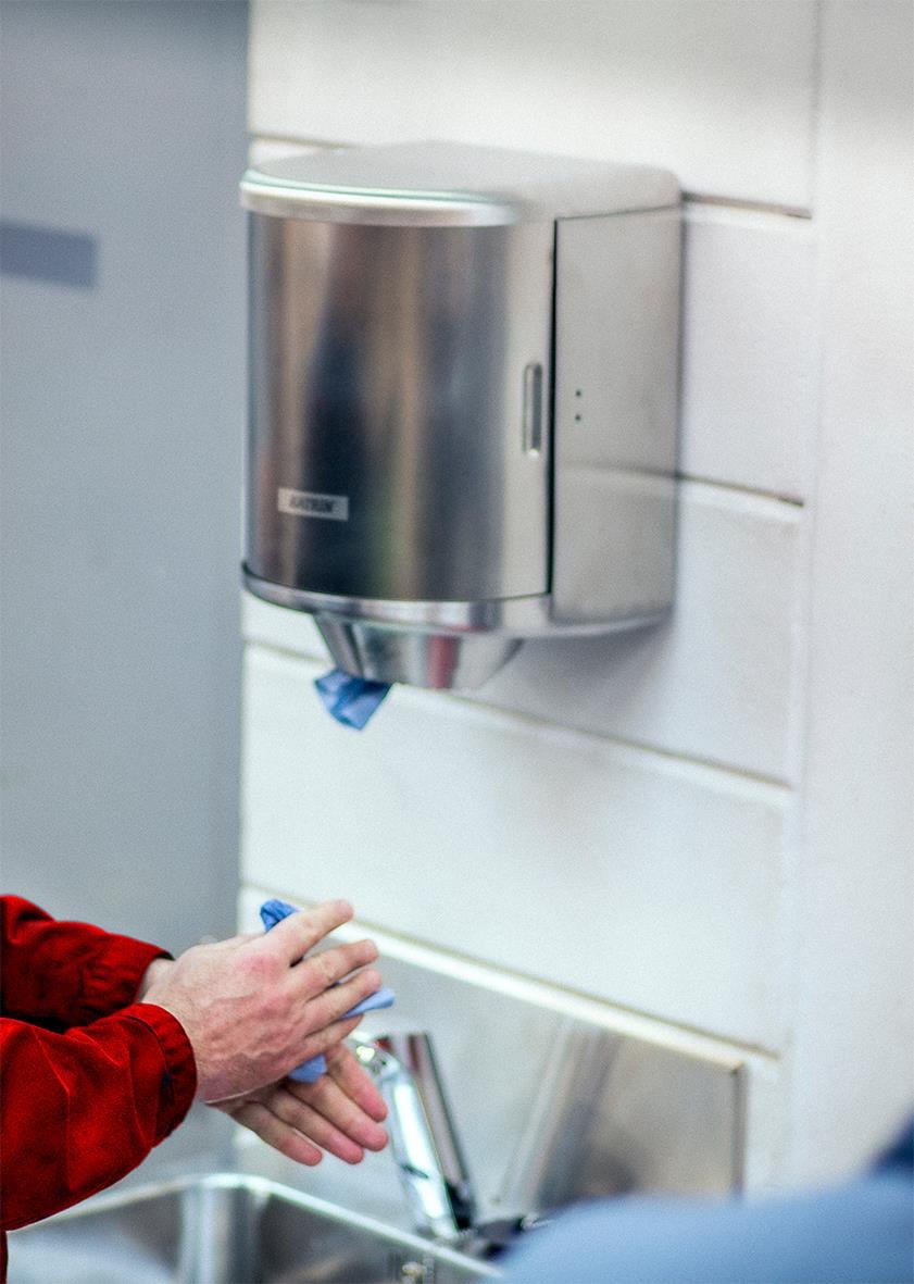 Rostfri dispenser för Katrin Centrummatad Torkrulle monterad på vägg, används för handtorkning