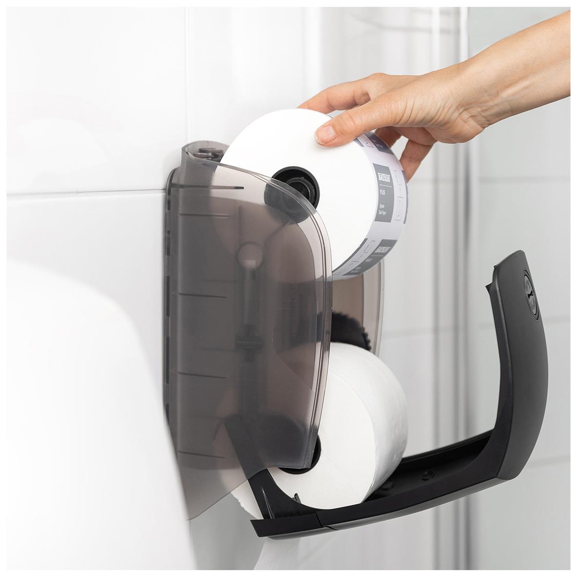 Vit Katrin toalettpappersdispenser med en hand som fyller på toalettpapper