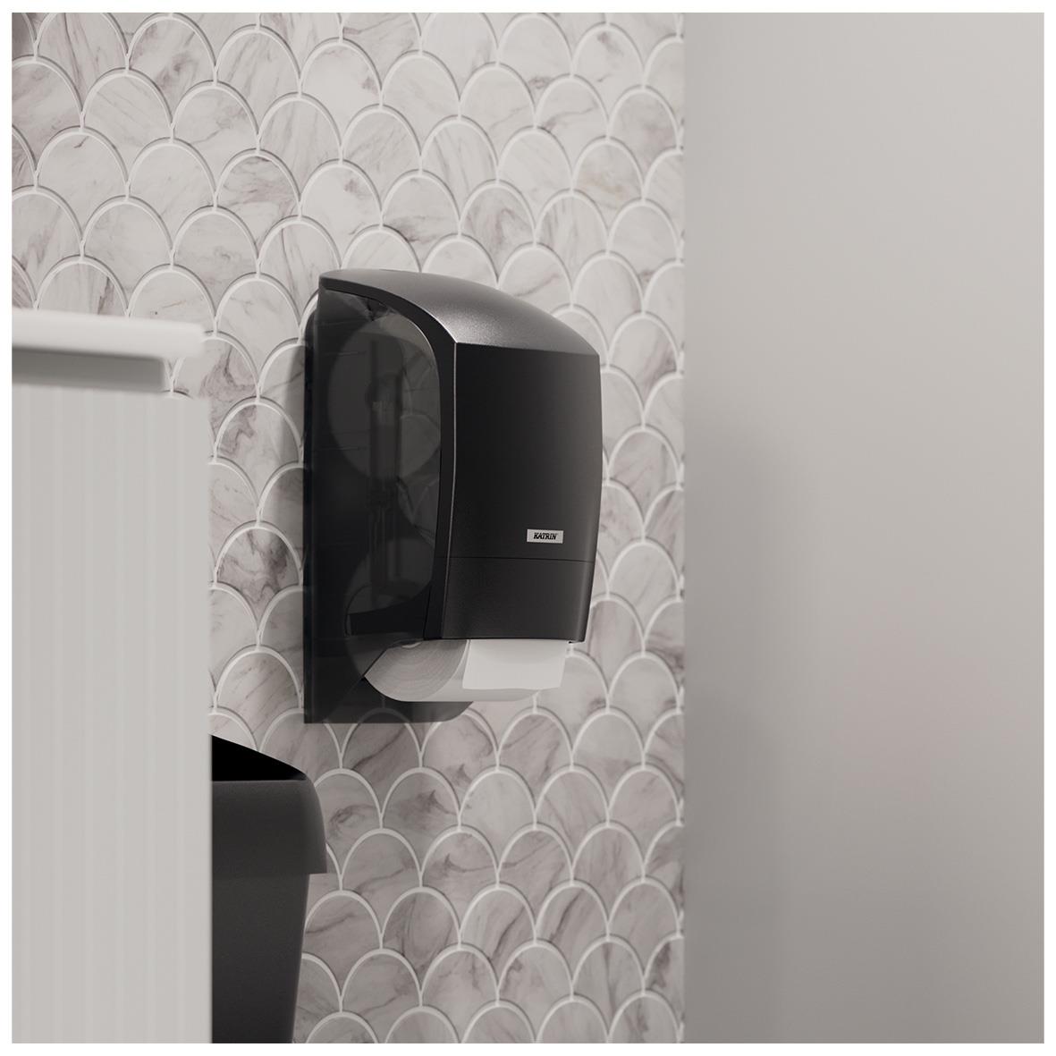 Vit Katrin system toalettpappersdispensär på vägg med mönstrad bakgrund